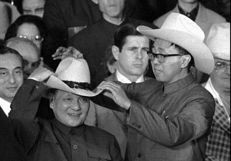 An aide helps then Chinese Vice Premier Deng Xiaoping try on a cowboy hat presented to him at a rodeo in Simonton, Texas Feb. 2, 1979. (AP)
